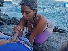 زوجان برازيليان ناضجان يستمتعان بالجنس الفموي في الهواء الطلق على الصخور