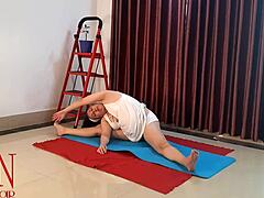 O femeie în lenjerie albă practică yoga în sală