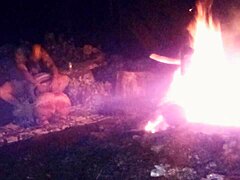 Un cuplu amator se bucură de un foc de tabără noaptea târziu