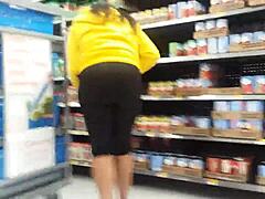 En svart jente viser frem den store baken sin i butikken