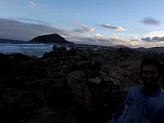 סרטון מעורר של נערה צעירה נותנת מציצה על הסלעים ליד הים