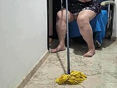 Зрела жена користи моп после гутања вруће мокре